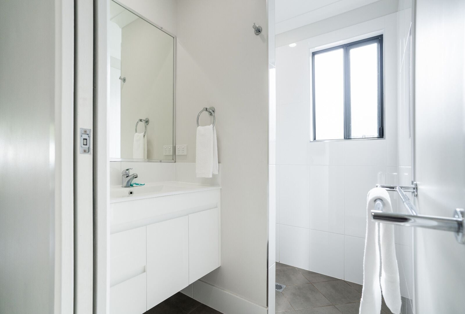 Ein modernes Badezimmer mit Waschbecken, Spiegel und Duschbereich.