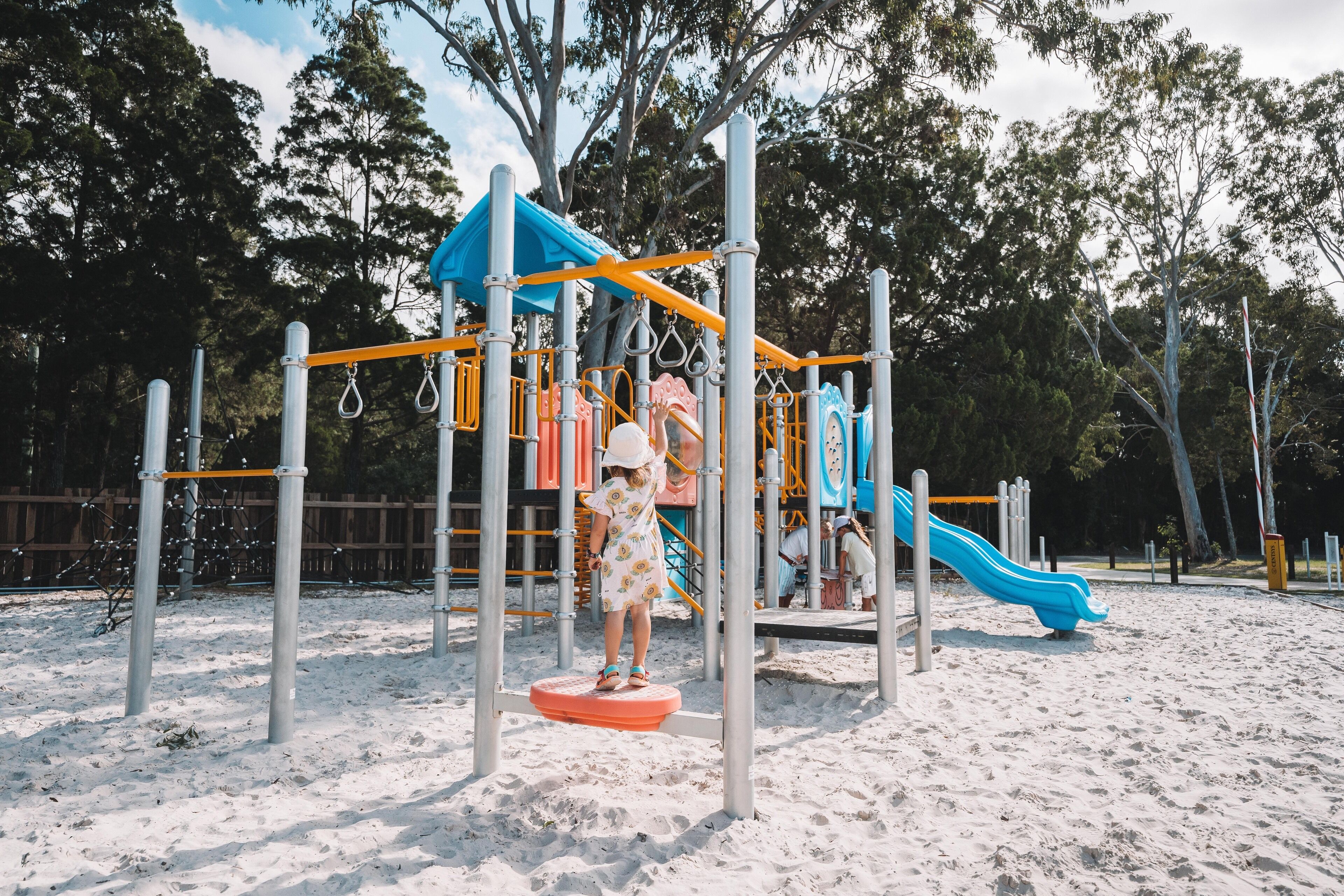 A playground with a slide and climbing structures.
