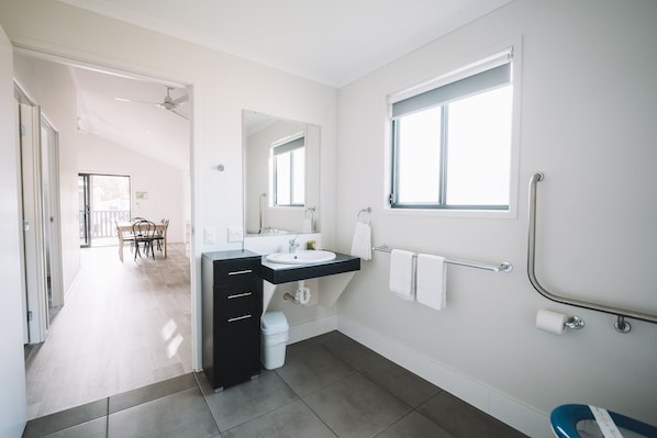 A modern bathroom with a sink, mirror, and window. - BIG4 Rainbow Beach Holiday Park (Rainbow Beach)