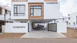 A modern building with a flat roof, large windows, and a covered entrance. - Treebo Corner Stay, Coimbatore (Coimbatore)