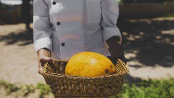A person holding a wicker basket with an orange.