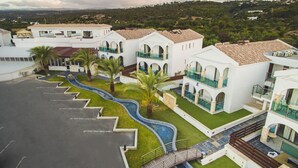 Un hôtel moderne doté de nombreux balcons, d’une piscine et d’un jardin aménagé.