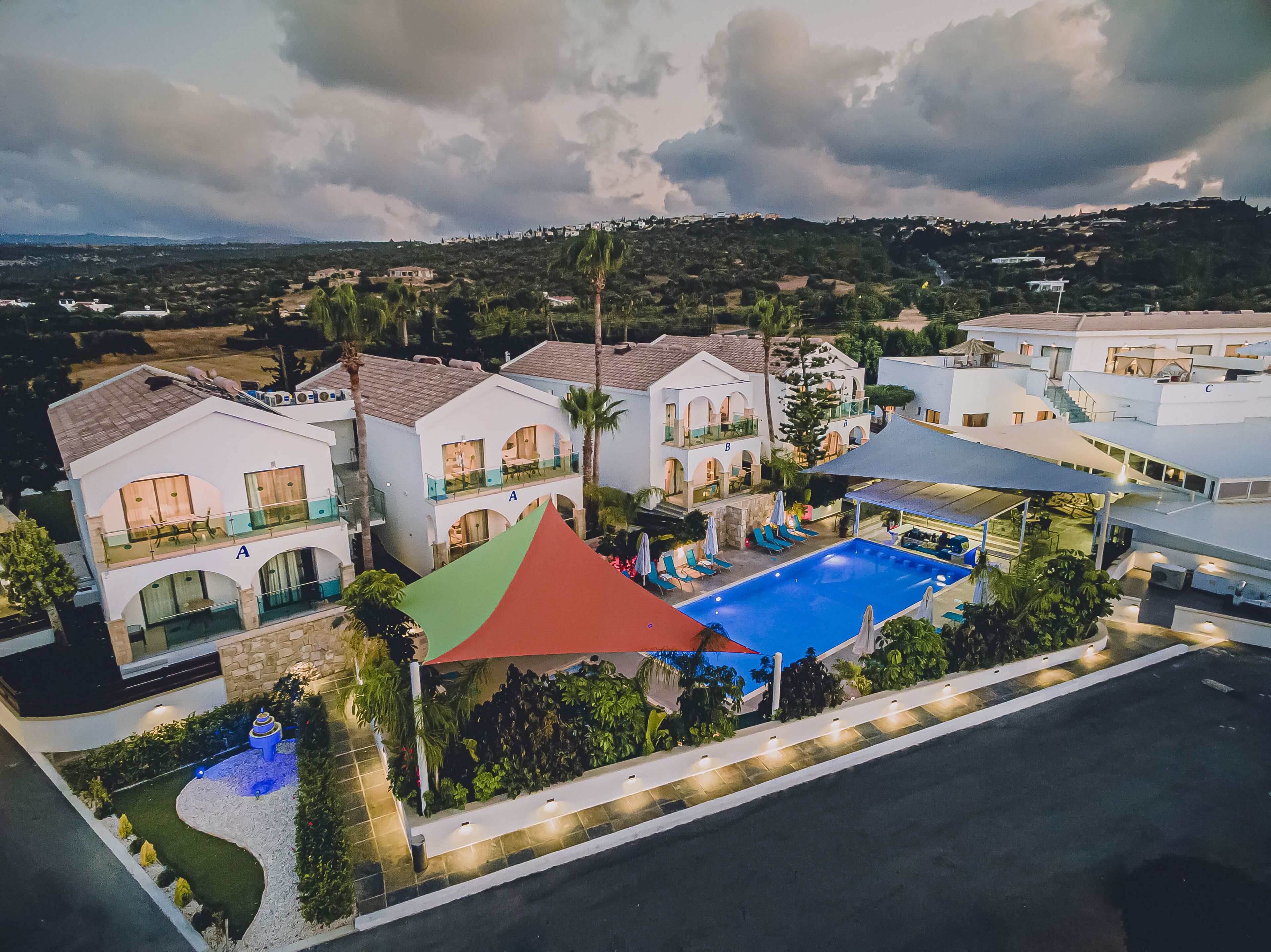Un resort con varias edificaciones, una piscina y un jardín ajardinado.