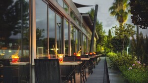 Un espace extérieur aménagé pour les repas, avec des tables et des chaises, un chemin et de la verdure.