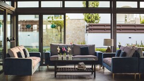 Un salon moderne avec un canapé, des fauteuils et une table basse.