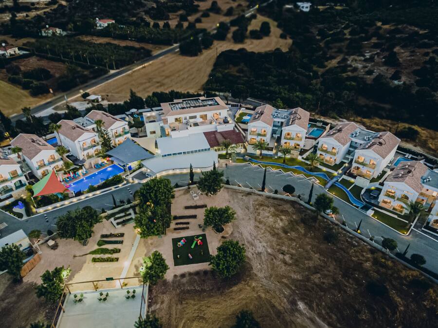Vista aérea de una zona residencial con casas modernas, una piscina y jardines ajardinados.