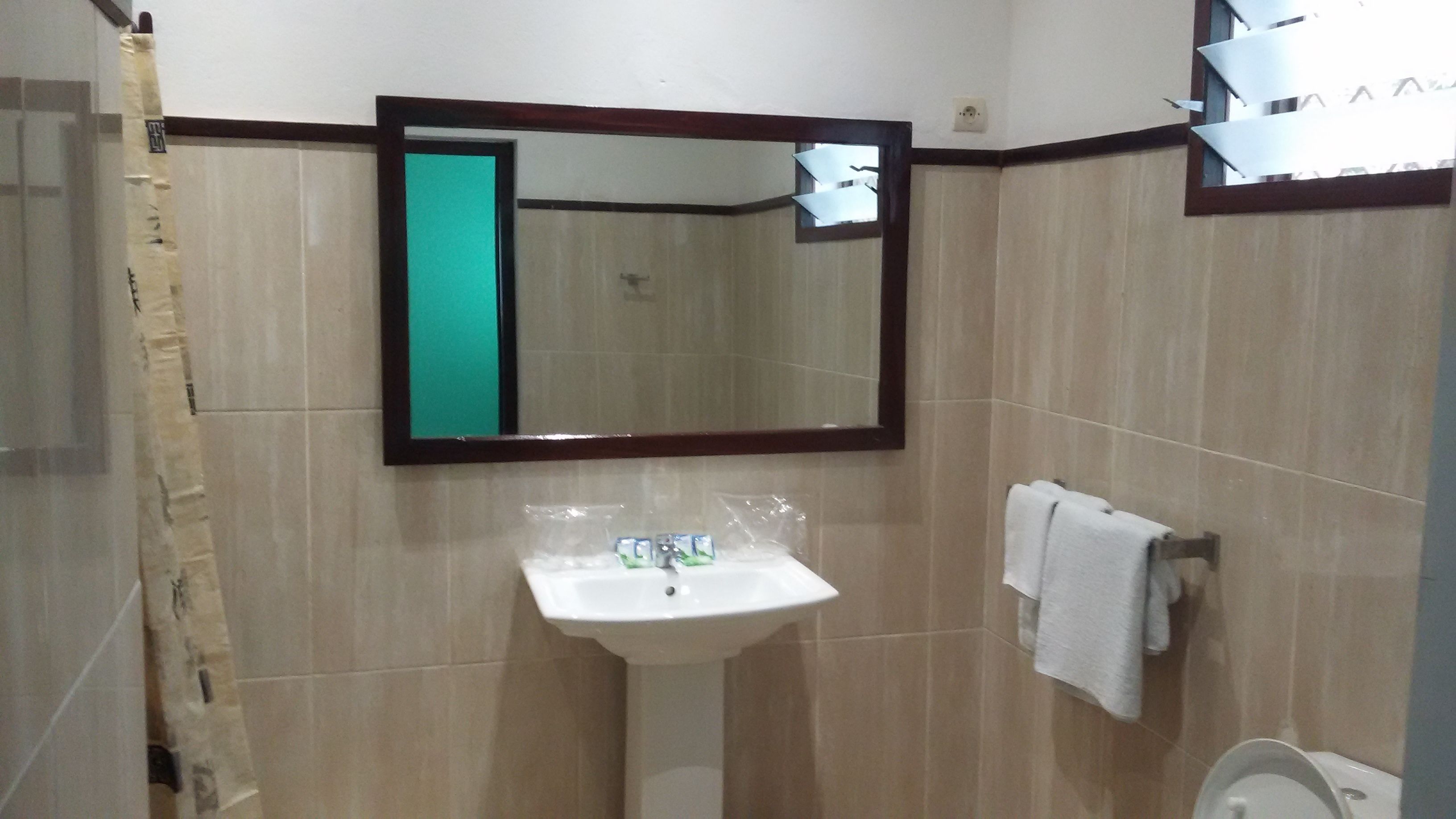 Ein Badezimmer mit Waschbecken, Spiegel und Handtuchhalter.
