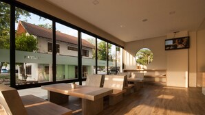 Un intérieur moderne avec de grandes fenêtres, des meubles en bois et un téléviseur à écran plat.