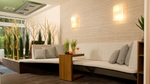 Una sala moderna con un sofá, una mesa de centro de madera y plantas decorativas.
