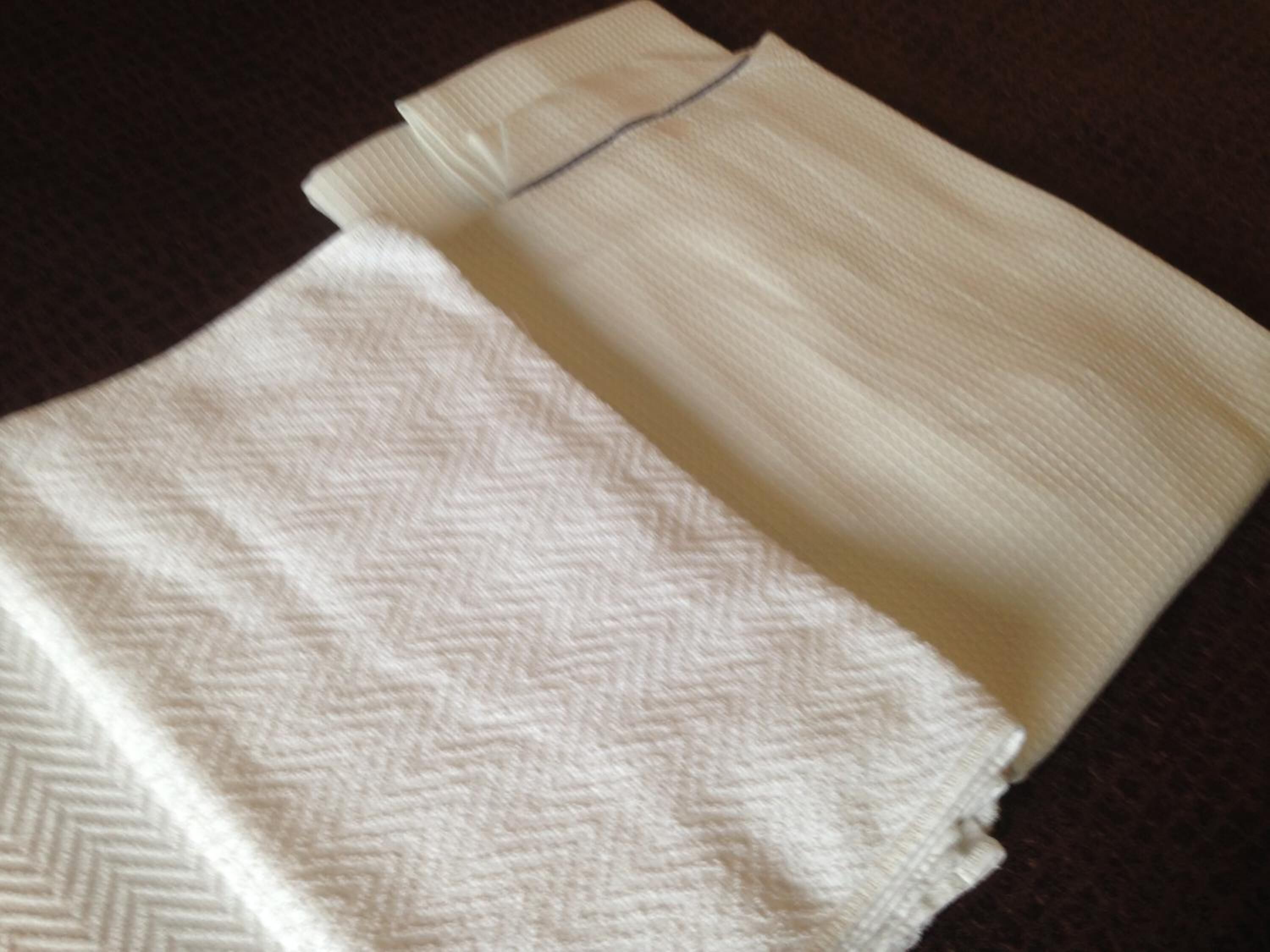 A folded white towel with a herringbone pattern.