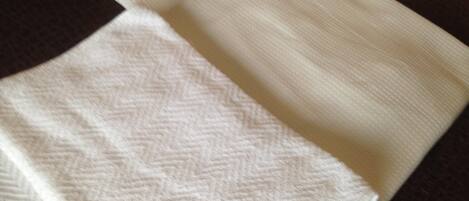 A folded white towel with a herringbone pattern.
