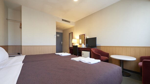 A hotel room with a large bed, a desk with a computer, a TV, and two chairs. - Hotel Select Inn Nagano (Nagano)