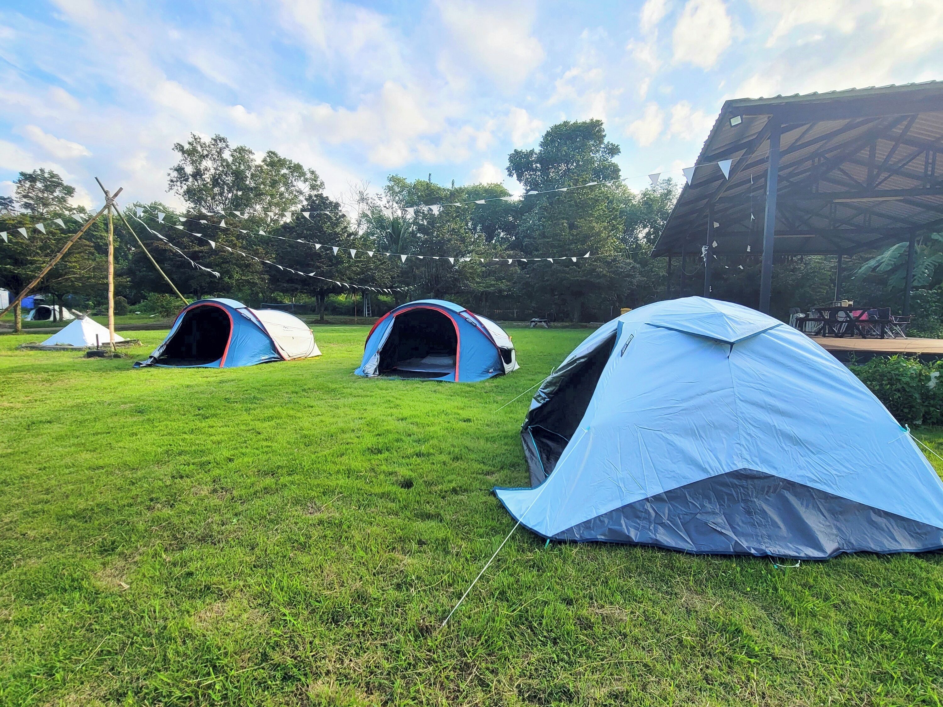 Un área de camping con césped y varias tiendas de campaña.