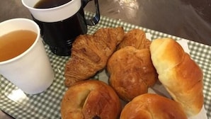 Une nappe à carreaux, une assiette de pâtisseries et une tasse de café.