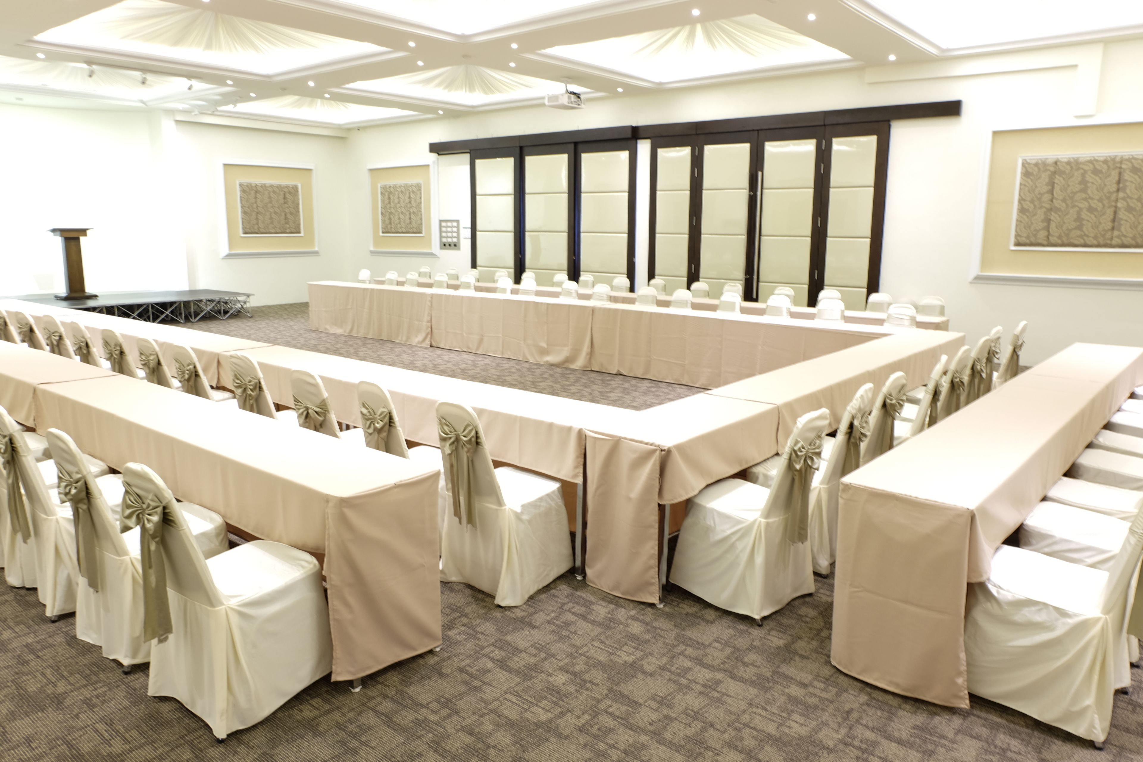 A conference room with a long table, chairs, and a podium.