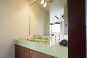 A bathroom with a sink, mirror, and toiletries.