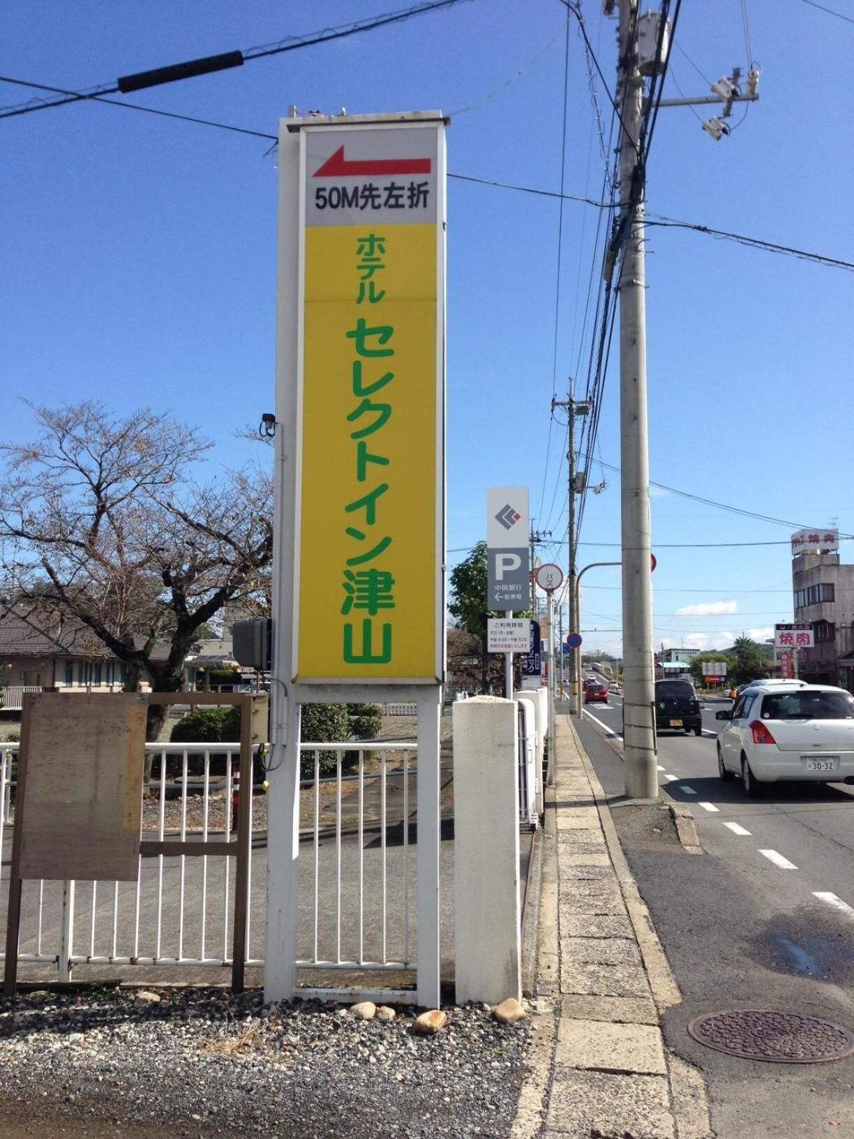 A street sign with Japanese text and a directional arrow.