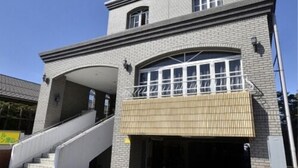 A two-story building with a brick facade, a covered entrance, and a staircase leading to the upper level. - Hotel Select Inn Tsuyama (Tsuyama)