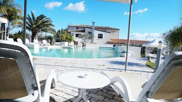 Een buitenzwembad en ligstoelen