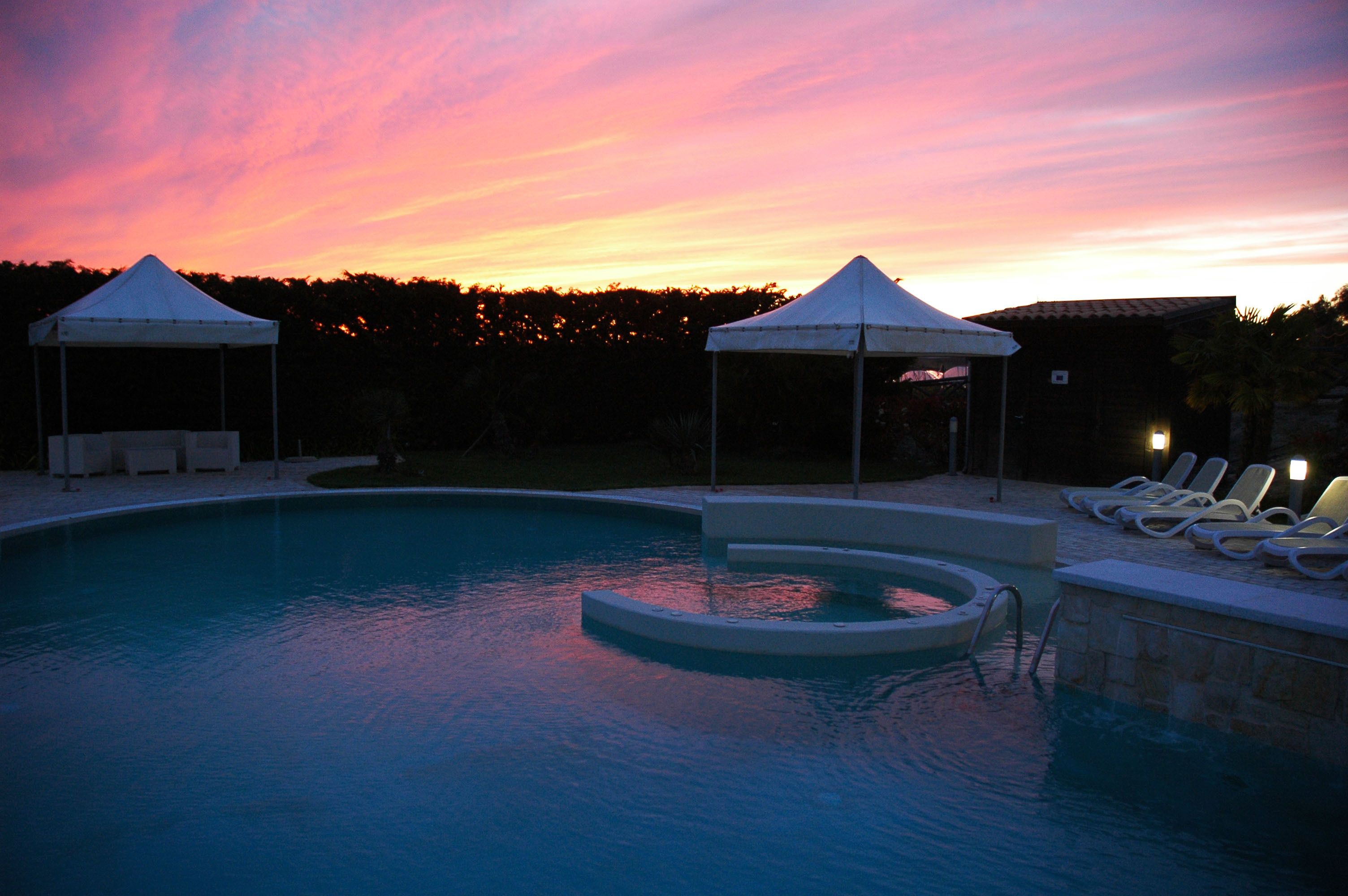 Een buitenzwembad en ligstoelen