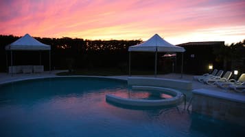 Een buitenzwembad en ligstoelen