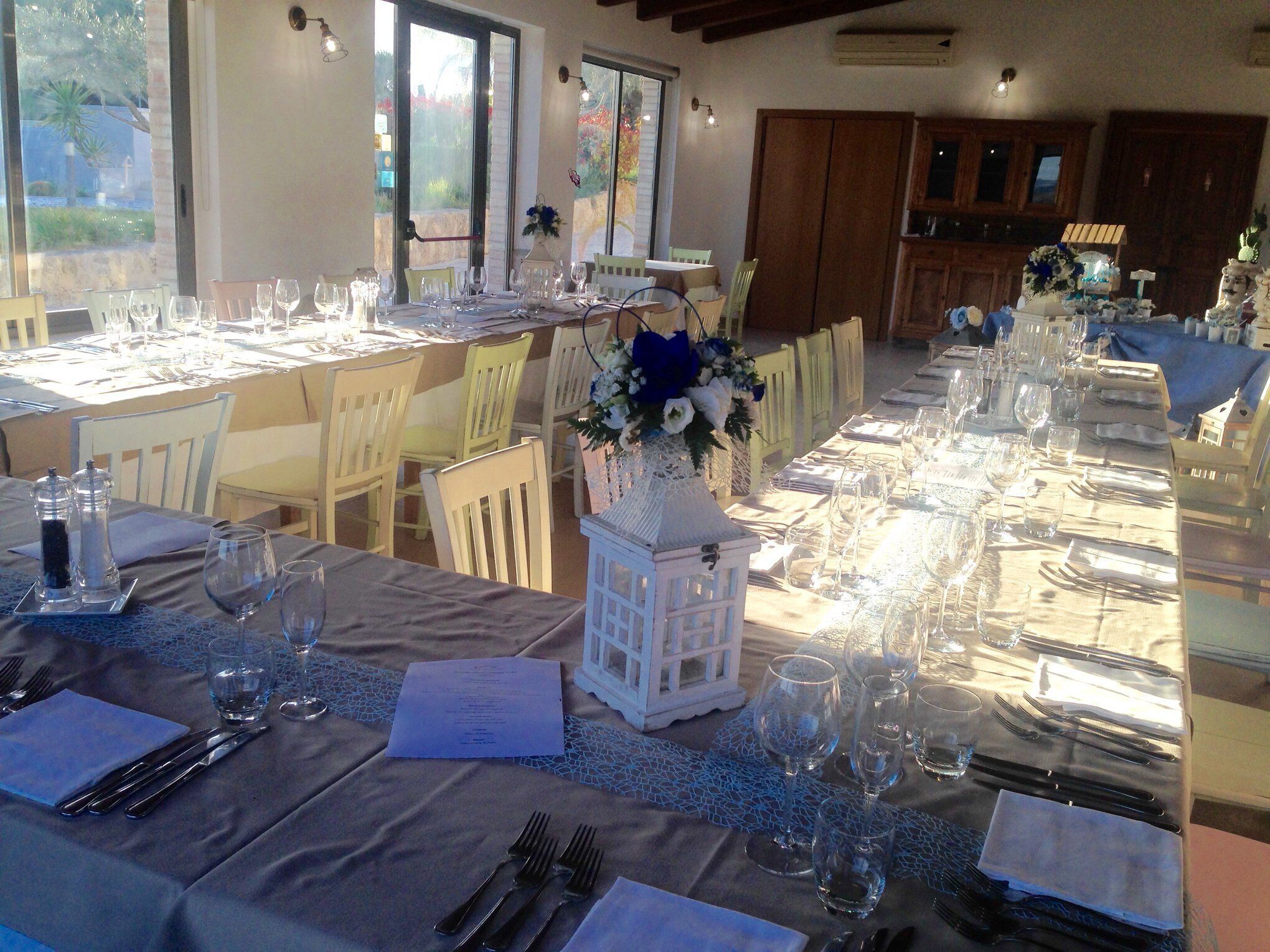A dining area with tables set for a meal, chairs, and a decorative centerpiece.