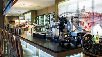 A bar area with a coffee machine, seating, and a large window with a cityscape view.