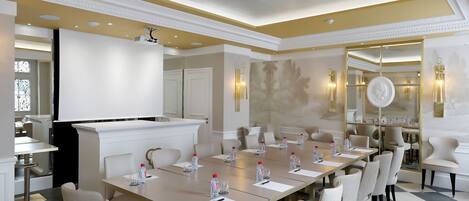A conference room with a long table, chairs, and a podium.