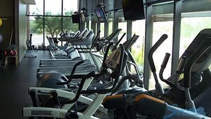 A gym with multiple treadmills and elliptical machines, large windows, and a view of greenery outside. - Rio Verde Townhouse By Signature Rentals (Rio Verde)