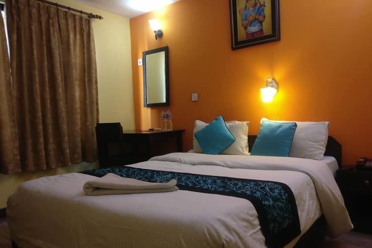A hotel room with a large bed, a desk, and a chair.