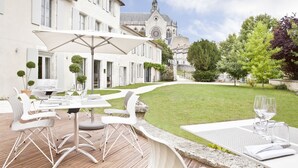 Une cour avec des sièges en plein air, une église en arrière-plan et une pelouse bien entretenue.