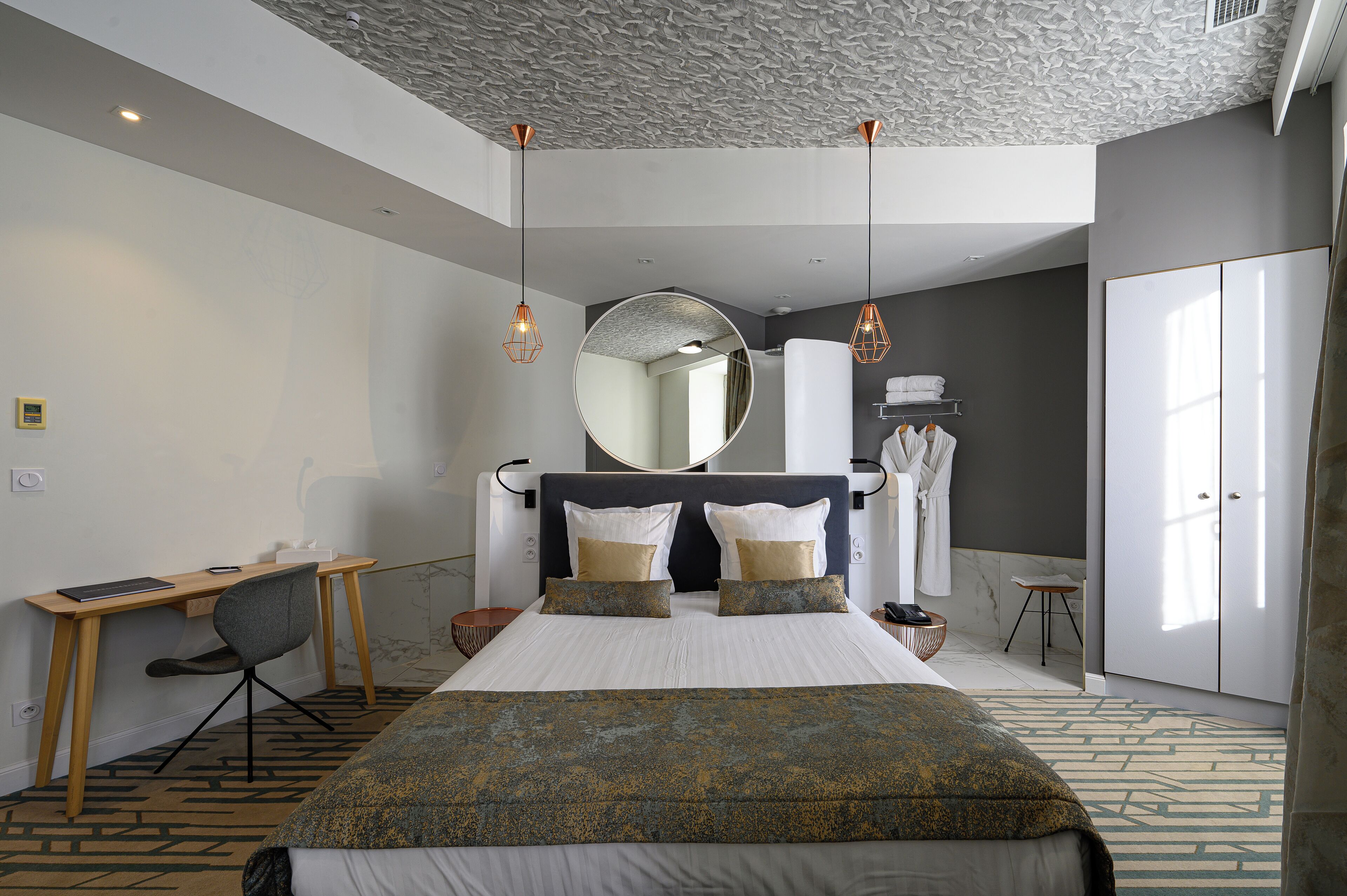 Una habitación de hotel moderna con una cama grande, un escritorio y una silla.