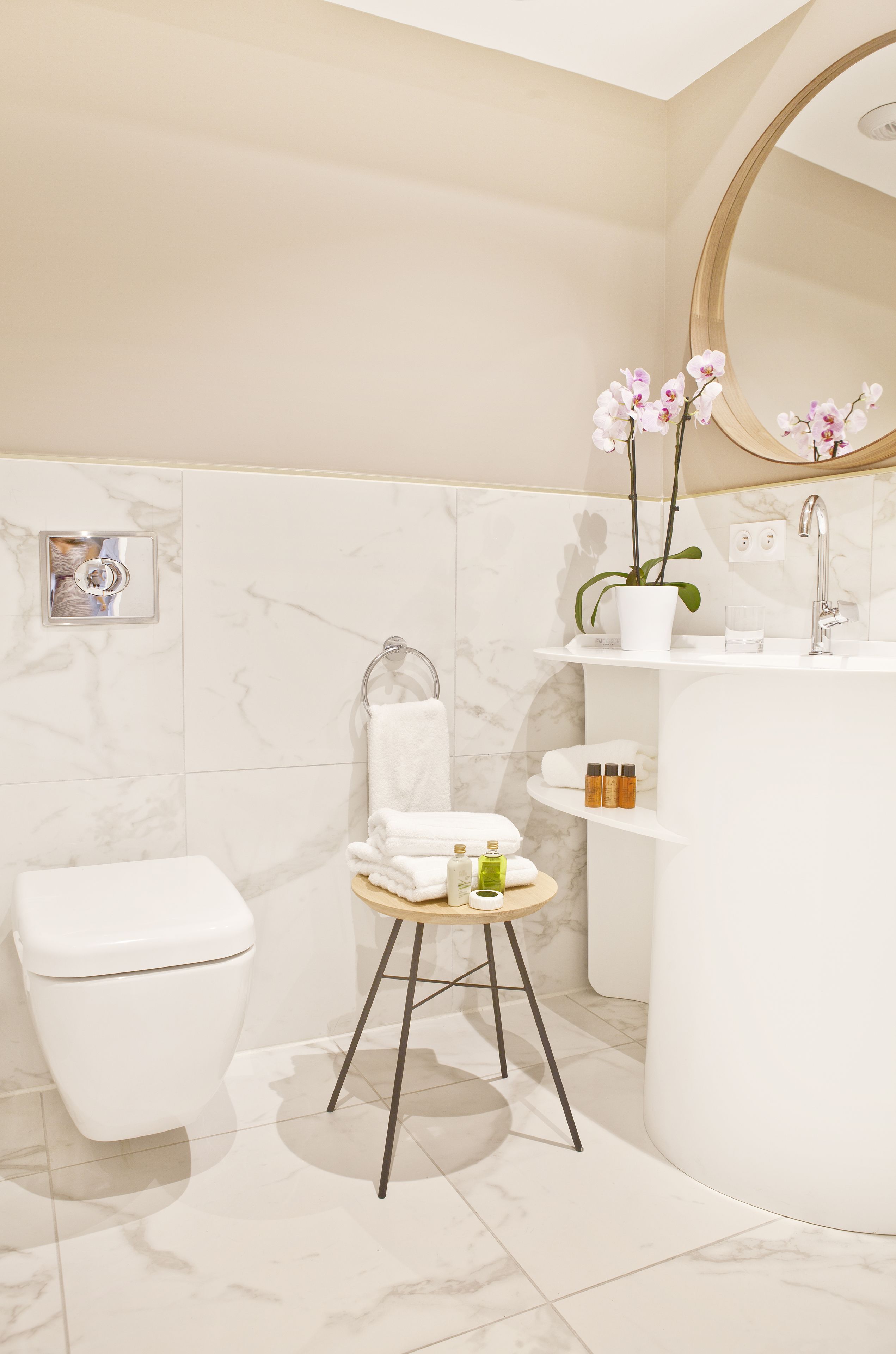 A modern bathroom with a toilet, sink, and mirror.