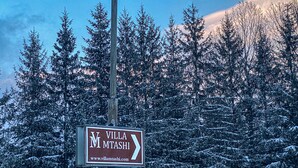 A sign for Villa Mtashi with directional arrows and a website URL. - Villa Mtashi (Borjomi)