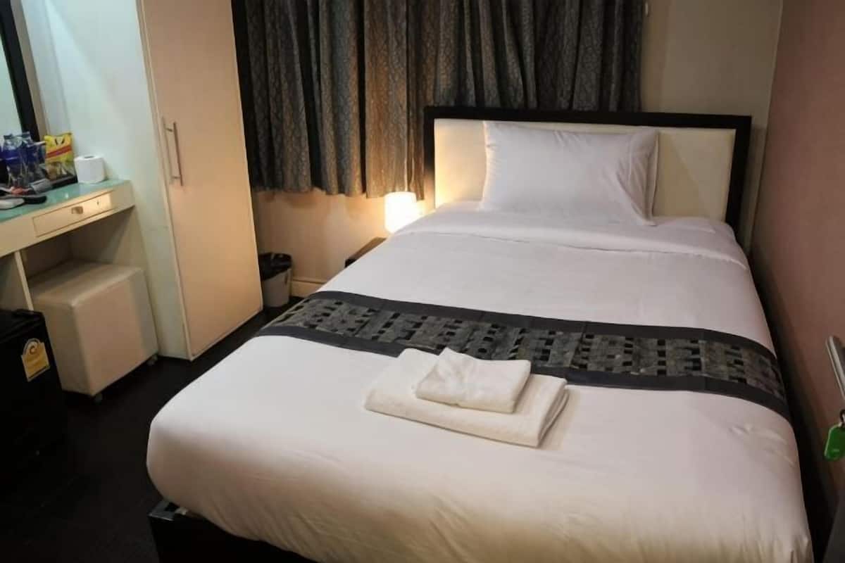 Une chambre d’hôtel avec un lit, un bureau et une table de chevet.