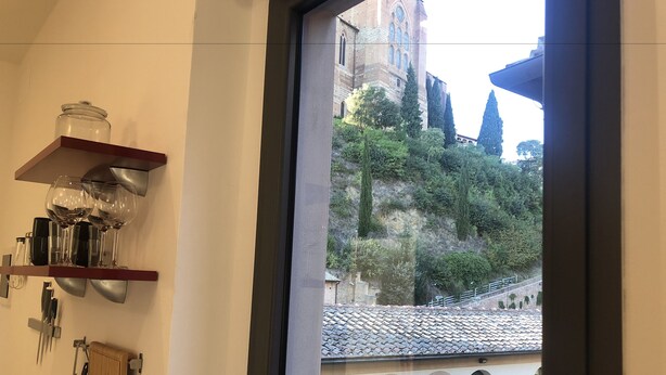 A bathroom with a window view of a historic building and a tiled roof.