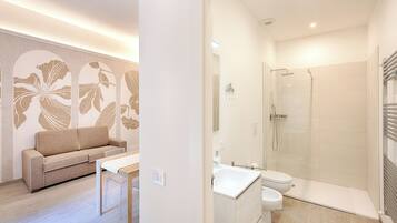 A modern bathroom with a glass shower enclosure, a white sink, and a toilet.