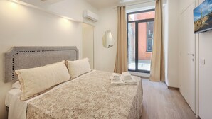 A bedroom with a large bed, a mirror, and a painting on the wall.