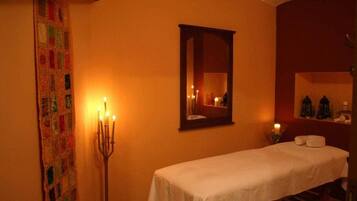 Cozy retreat with a single bed, candelabra, and mirror.