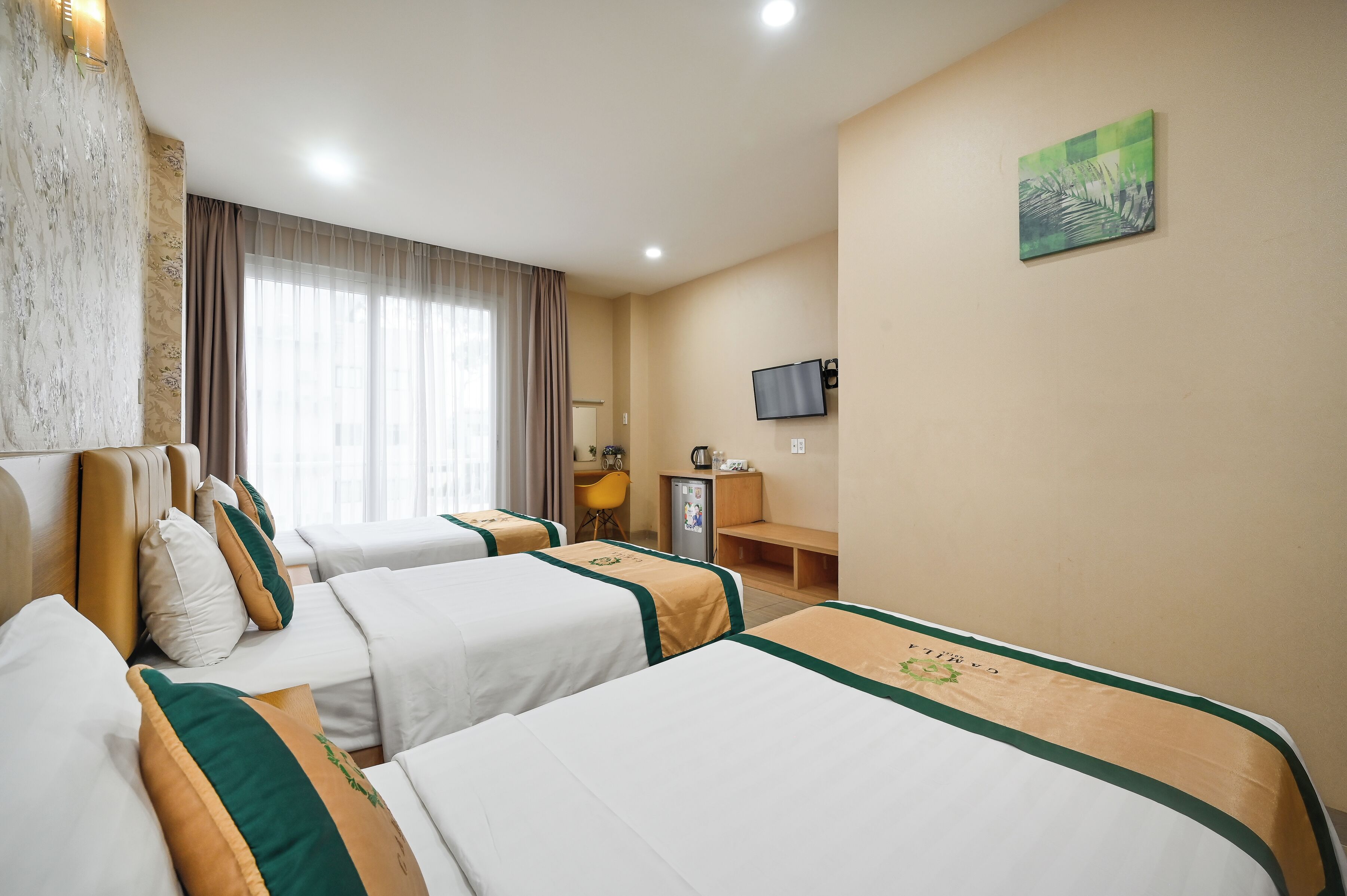 A hotel room with two beds, a desk, a chair, a television, and a painting on the wall.