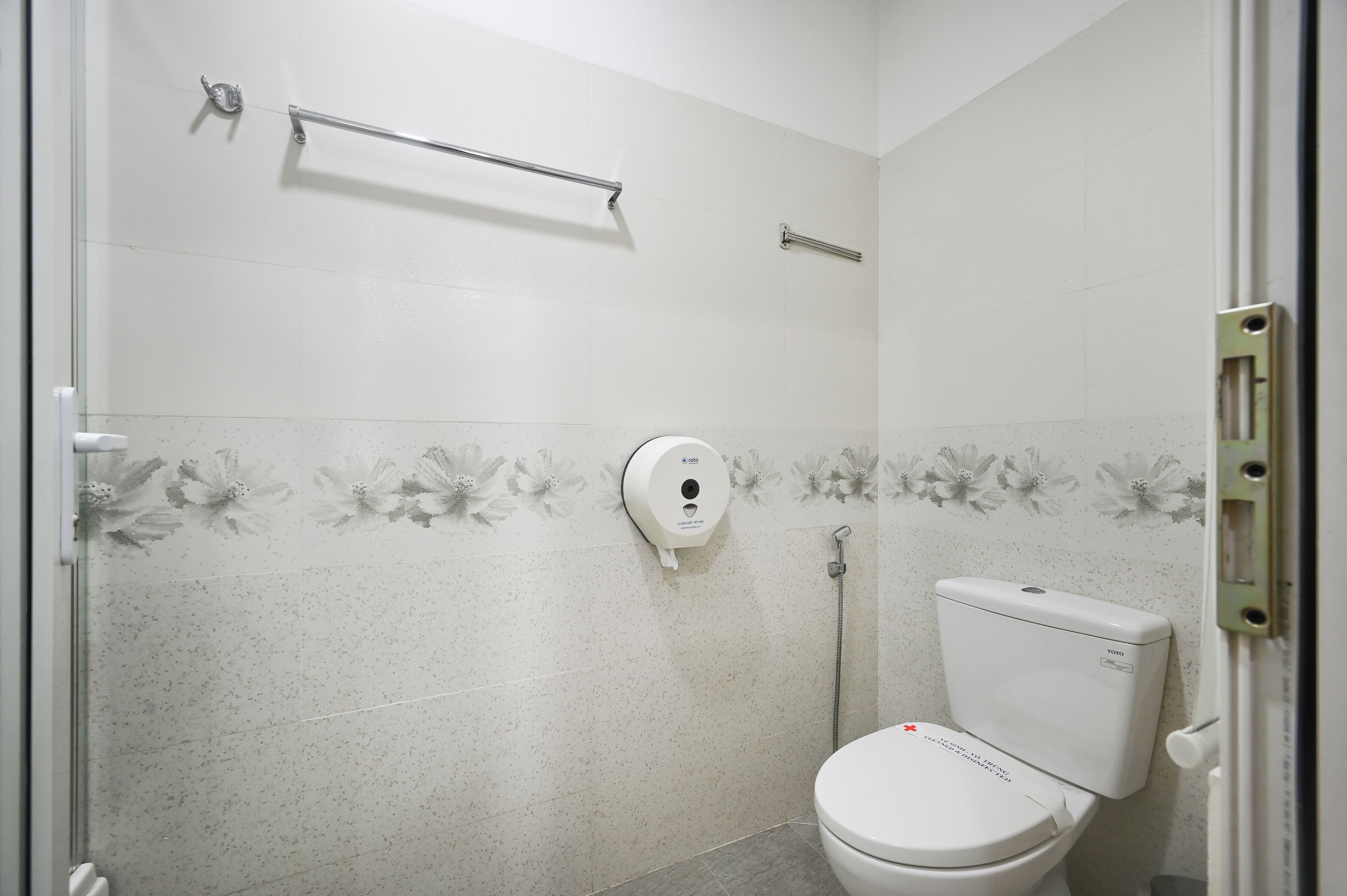 Une salle de bain équipée de toilettes, d’un sèche-mains et d’un espace douche.