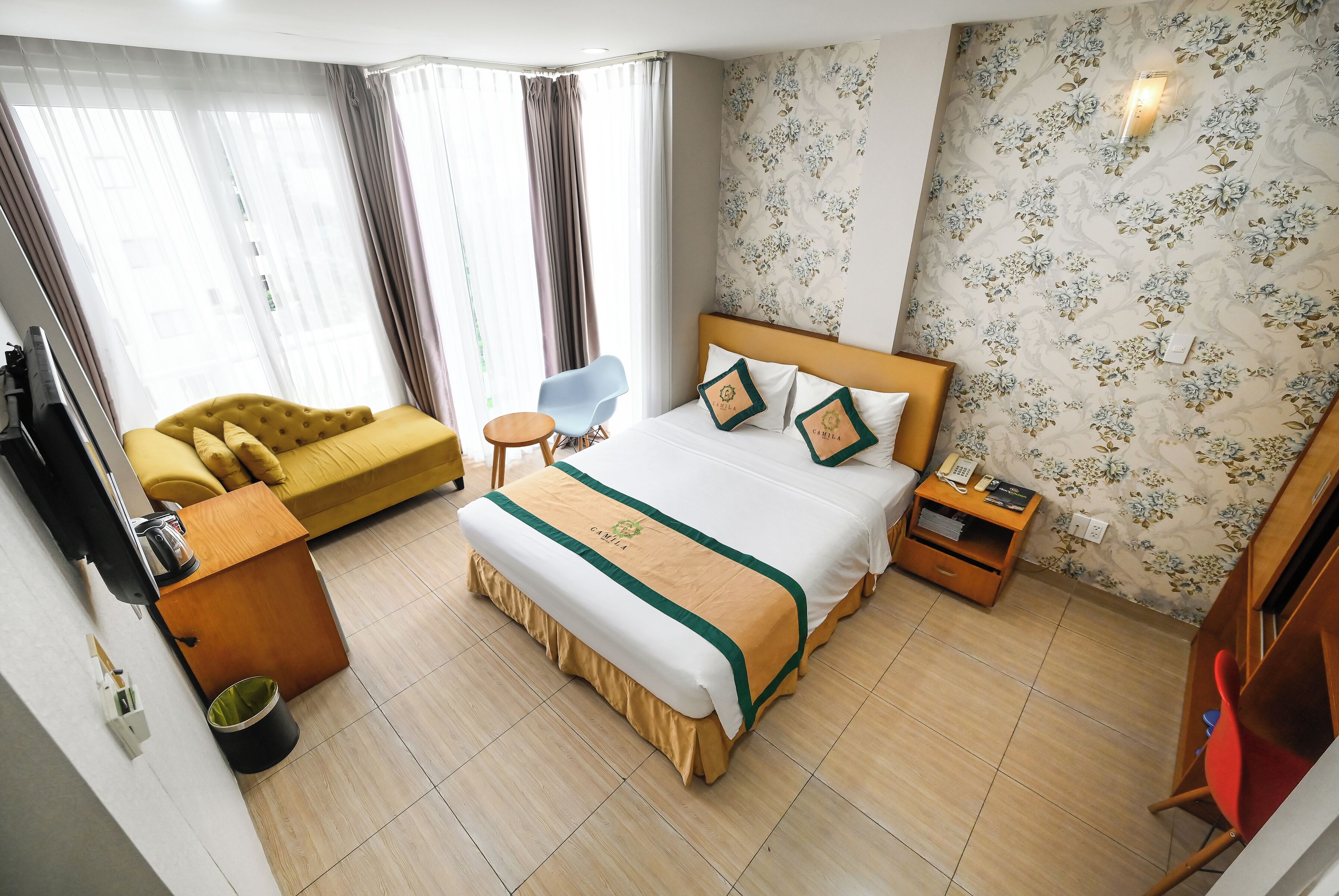 Une chambre d’hôtel comprenant un lit, un canapé, une chaise, un bureau et une table de chevet.