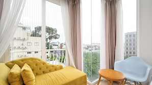 A room with a yellow sofa, a blue chair, and a small wooden table.