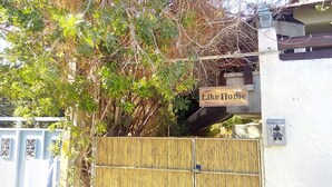 Ein Bambuszaun, ein Schild mit der Aufschrift 'Like Home' und die Hausnummer 7.