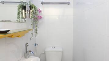 A bathroom with a white sink, toilet, and a blue ceiling.