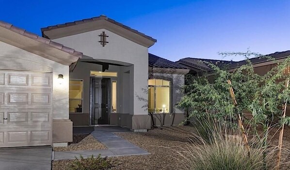 A residential house with a garage, a front door, and a small garden area.