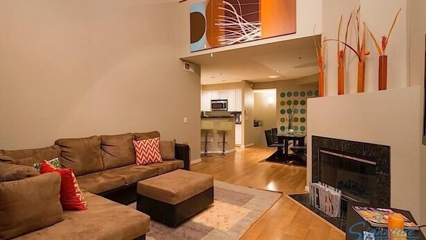 A modern living room with a sectional sofa, a fireplace, and a dining area in the background. - Phoenix Palms By Signature Vacation Rentals (Phoenix)