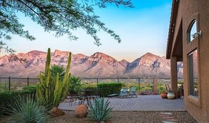 A patio with outdoor furniture, a cactus garden, and a mountain view.
