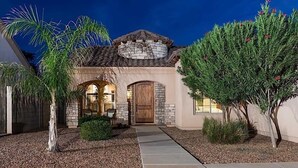 A house with a stone facade, a wooden door, and a tiled roof. - Sail Away By Signature Vacation Rentals (Chandler)