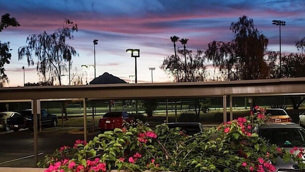 A parking lot with cars and a building with a flat roof. - Parktopia By Signature Vacation Rentals (Scottsdale)